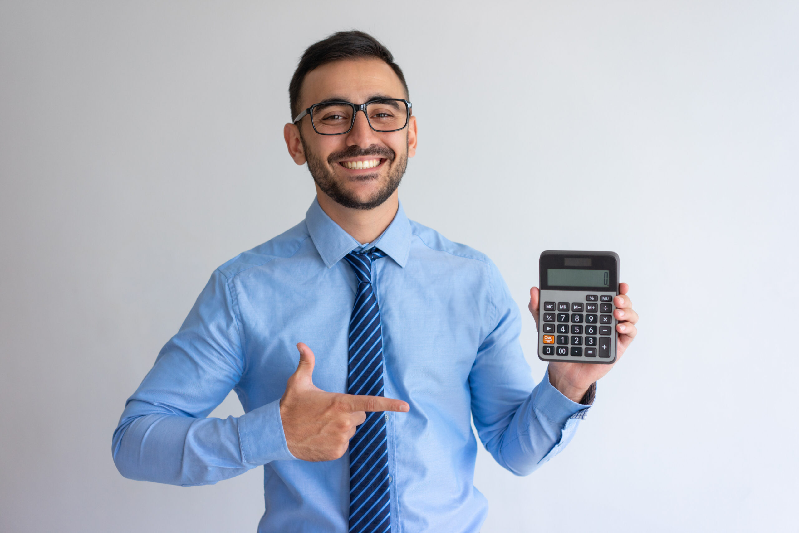 Cheerful banker advertising loan program. Content young man in glasses and tie pointing at calculator. Finance or banking concept